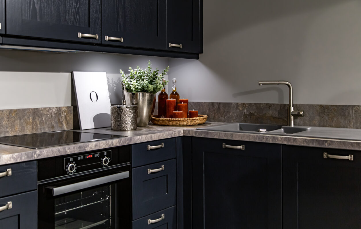 Dark kitchen cabinets with metal pulls or knobs in home interior.